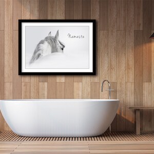 Pu&ograve; includere: Una fotografia in bianco e nero di una testa e un collo di cavallo, con il testo "Namaste" stampato sull'immagine. La fotografia &egrave; incorniciata e appesa a una parete in un bagno con una vasca da bagno bianca e un pavimento in legno.