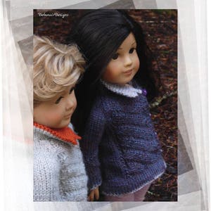 May include: Two dolls wearing knitted sweaters. The doll on the left has blonde hair and is wearing a light gray sweater with an orange collar. The doll on the right has long black hair and is wearing a purple sweater.