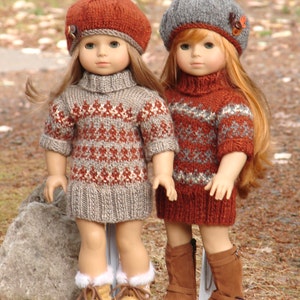 May include: Two dolls wearing brown and gray knitted sweaters and brown boots. The dolls are wearing berets, one is red and the other is gray. The dolls are standing on a path with leaves on the ground.