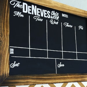 Può includere: Una lavagna nera con cornice in legno, etichettata "The Deneves this week" con i giorni della settimana elencati di seguito: Lun, Mar, Mer, Gio, Ven, Sab, Dom. La lavagna ha una sezione etichettata "Dates:"