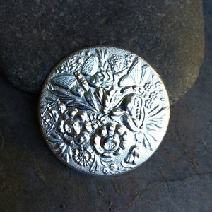 The Twisted Eye Silver Plated Medalion with Flowers and Butterflies Stamping Made in the USA