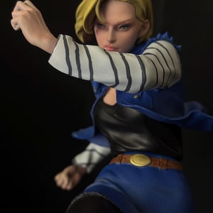 May include: A blonde haired action figure with a blue skirt, black leggings, and a striped shirt. The figure is wearing a black and blue jacket and has a gold belt buckle.