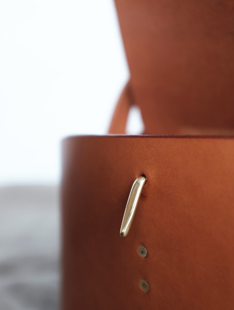 May include: A brown leather box with a gold metal latch. The box is open and the inside is visible.