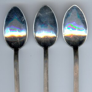 Peut inclure: Trois cuillères en argent avec des motifs géométriques ornés sur les manches. Les cuillères ont un bol arrondi de forme ovale.