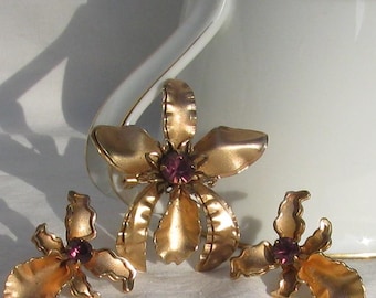 Conjunto de joyas vintage Bugbee & Niles de los años 30 con diseño de orquídea, pétalos dorados en capas con diamantes de imitación morados, broche y pendientes a juego.