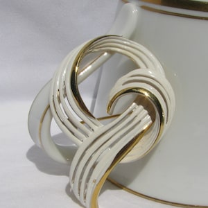 Broche de cinta calada esmaltada blanca con cartela firmada por MONET, estilo retro glorioso de los años 70, en tono dorado, accesorio vintage para dama de 2 y 1/8", estilo veraniego