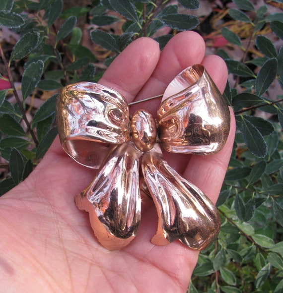 Bow brooch deals