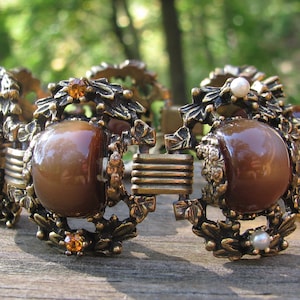 Eccezionale bracciale vintage da donna riccamente decorato, anni '50, non firmato, in termoindurente laminato color marrone topazio con strass dorati e perle finte