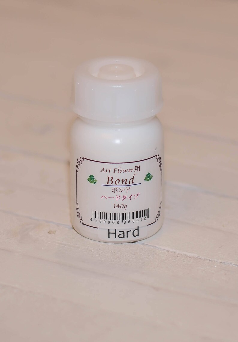 May include: A white bottle of Art Flower Bond Hard glue, labelled in Japanese with a barcode and the text "Hard".