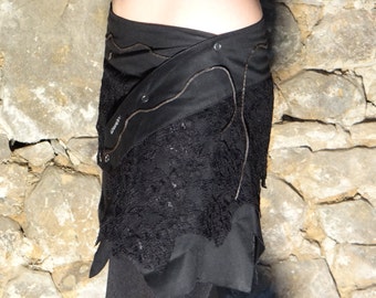 Mini jupe, Sur jupe en dentelle et coton noir décoré de lacets de cuirs et pressions.