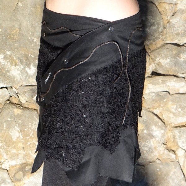 Mini jupe, Sur jupe en dentelle et coton noir décoré de lacets de cuirs et pressions.
