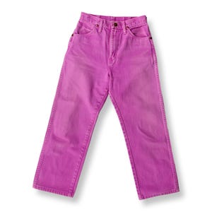May include: A pair of high-waisted, straight-leg jeans in a vibrant magenta hue. The jeans feature classic five-pocket styling, a button and zipper closure, and belt loops. The denim appears to be pre-washed for a faded look.