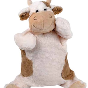 Puede incluir: Un títere de vaca de peluche marrón y blanco con una cara sonriente. La vaca tiene una textura suave y peluda y es perfecta para juegos imaginativos.