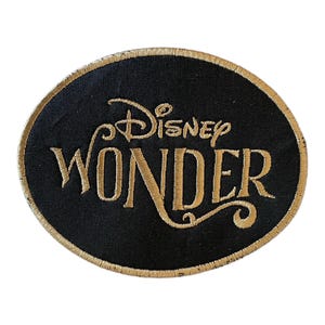 May include: A black oval patch with gold embroidered lettering that reads "Disney Wonder".