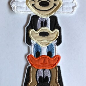 Könnte beinhalten: Ein Stapel gestickter Aufnäher mit Mickey Mouse, Donald Duck und Goofy. Die Aufnäher sind im Cartoon-Stil gehalten und perfekt, um jedem Projekt einen Hauch von Disney-Magie zu verleihen.