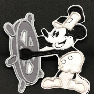Könnte beinhalten: Schwarz-weiß gestickter Bügel-Patch von Mickey Mouse, der ein Schiffsrad hält. Der Patch ist etwa 15 cm x 15 cm groß.