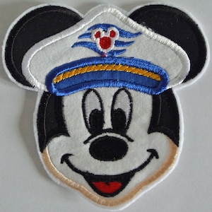 Könnte beinhalten: Ein gestickter Aufnäher von Mickey Mouse, der einen blauen und gelben Kapitänshut mit einem roten und weißen Disney Cruise Line Logo trägt.
