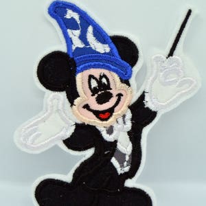 Könnte beinhalten: Ein gestickter Aufnäher von Mickey Mouse, der einen blauen Zaubererhut trägt und einen Zauberstab hält. Der Aufnäher ist 10 cm groß.