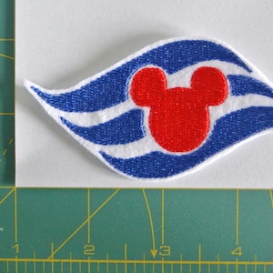 May include: White embroidered patch with a blue wave design and a red Mickey Mouse head in the centre. The patch is approximately 7.5 cm wide.