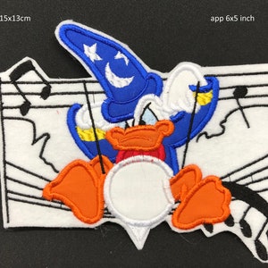 Può includere: Un toppa ricamata da stirare con un papero dei cartoni animati che indossa un cappello da mago blu con una mezzaluna e stelle. Il papero sta suonando un tamburo con note musicali sullo sfondo. La toppa misura circa 6x5 pollici.
