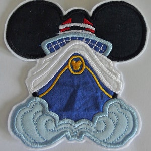 Puede incluir: Un parche bordado azul y blanco de Mickey Mouse con un sombrero de capitán y un barco con un ancla amarilla. El barco está rodeado de nubes blancas.