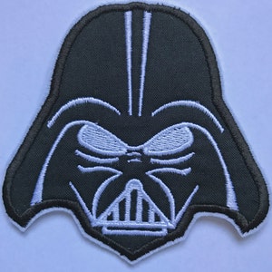 Può includere: Toppa ricamata in bianco e nero del volto di Darth Vader di Star Wars.