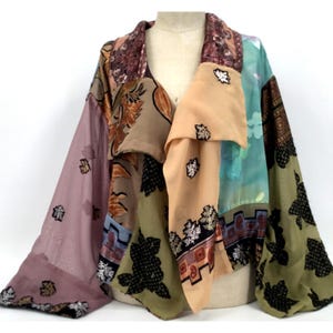 May include: A patchwork jacket featuring a variety of fabrics in shades of mauve, tan, olive green, and teal. The garment includes panels with floral and geometric patterns, black velvet-like leaf appliques, and a sequined collar detail.