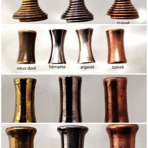 May include: Close-up of three different metal finishes: old gold, hematite, and silver. The metal finishes are shown in three different forms: a spiral, a cylinder, and a cylinder with a wider base. The metal finishes are labeled in French.