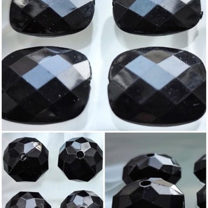 Könnte beinhalten: Ein Satz mit sechs schwarzen facettierten Glasperlen. Vier der Perlen sind rechteckig und zwei sind rund.