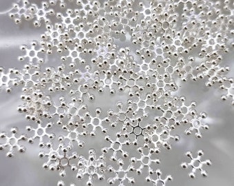 May include: A large quantity of silver snowflake charms, each with a delicate, intricate design. The charms are made of metal and have a shiny finish.