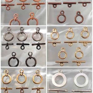 Peut inclure: Assortiment de fermoirs à bascule en métal dans différentes finitions, notamment argent, or, cuivre et noir. Chaque fermoir est doté d'un anneau rond et d'une barre droite.