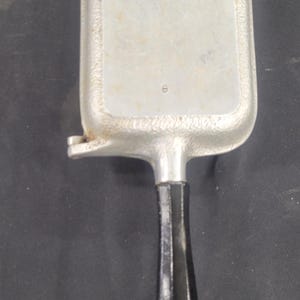 May include: Vintage Silver Seal waffle iron. The rectangular iron is made of silver-colored metal with a black handle. The handle is attached to the iron with a hinge. The iron has the words "Silver Seal" on the top.