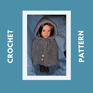 Peut inclure: Une cape à capuche en crochet gris avec des boutons en bois pour une poupée. La poupée porte la cape et a les cheveux bruns et les yeux bruns.