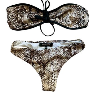 Op de afbeelding: Een tweedelige bikini met een slangenprint in bruin, zwart en crème. De bandeau-top heeft een zwarte bies en een strik in het midden. Het bikinibroekje heeft een hoog uitgesneden model en een zwart label met Roberto Cavalli Beachwear.