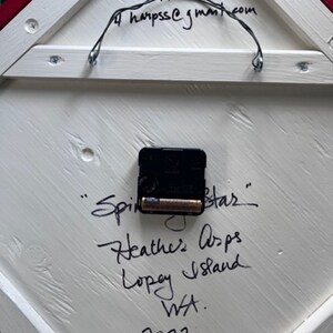 Shows back of hand painted Barn Quilt clock with clock works and artist's signature and date.
