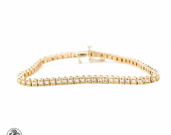 May include: A gold tennis bracelet featuring a row of small, round diamonds set in a pave setting.