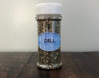 Peut inclure: Un pot en verre transparent avec un couvercle blanc rempli de dill frais. Le pot porte une étiquette bleu et blanc qui indique "K&C Creations" et "DILL".