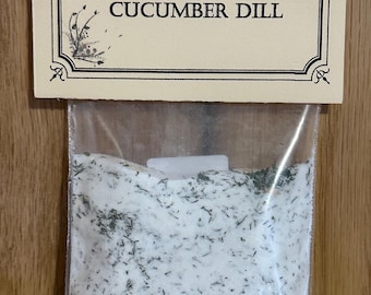 May include: A clear plastic bag filled with white salt and green dill, labeled "Kare & Cher Creations Cucumber Dill".