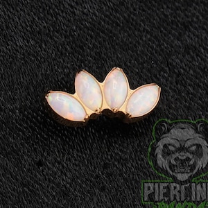 May include: A rose gold tone body jewelry piece featuring four marquise-cut white opalescent stones arranged in a fan-like arc shape. The stones display iridescent flashes of color against the metallic setting, creating a curved decorative design.