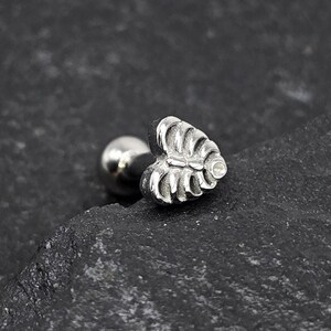 May include: Silver body jewelry with a heart-shaped leaf design and a small clear stone.