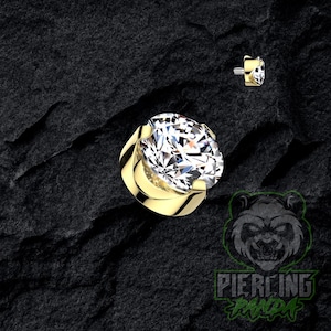 Pode incluir: Um conjunto de três canecas de cerâmica com acabamento fosco e salpicado. As canecas são em tons de creme, cinza claro e cinza escuro. Cada caneca tem um design simples e minimalista.