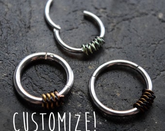 May include: Three silver-toned metal hoop rings with hinged closures. Each ring features a section wrapped in thin wire. One ring has green wire, while the other two have dark brown and black wire. The text "FEATHERBLUEJEWELRY" and "CUSTOMIZE!" appear.