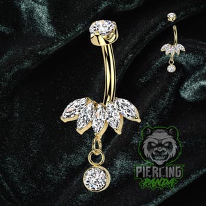 Piercing de umbigo em titânio 14g com gemas em formato de marquise, grau implante, cravação interna com garras e banho de ouro PVD.