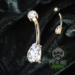 Piercing de umbigo redondo em titânio 14g com gema em formato de pera, grau implante, rosca interna na parte superior e cravação com garras. Banhado a ouro PVD.