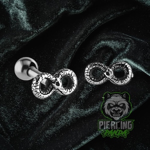 May include: A pair of silver-colored infinity symbol earrings and a barbell stud. The infinity symbols have a textured, snake-like design. The image also includes a logo with a panda and the words "Piercing Panda."