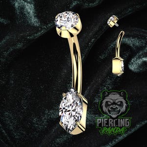 Piercing de umbigo em titânio dourado 14g com zircônia cúbica branca em formato de marquise, grau implante ASTM F136, rosca interna e cravação superior com garras.