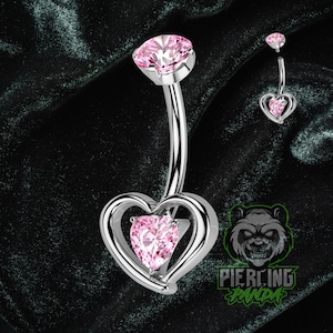 Piercing de umbigo com rosca interna em titânio, calibre 14g, com zircônia cúbica rosa em formato de coração e cravação dupla em garras.