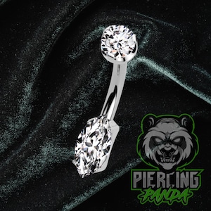 Piercing de umbigo em titânio ASTM F136 com zircônia cúbica branca em formato de marquise, grau implante, rosca interna e cravação em garras.