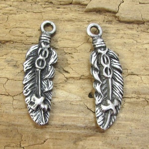 May include: Two silver-toned feather charms with a detailed design. Each charm has a loop at the top for attaching to jewelry or other crafts.