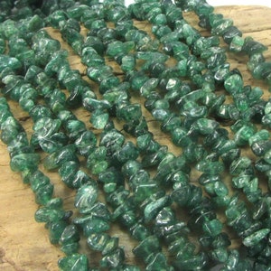 May include: A strand of green aventurine chip beads. The beads are small and irregular in shape, and they have a slightly translucent appearance.